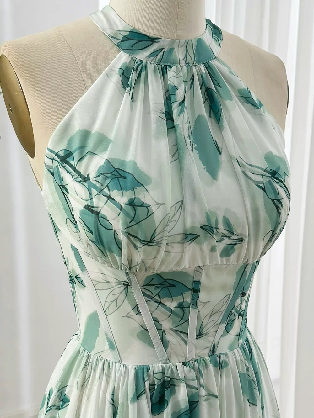 Flowy corset halter maxi gown with pleated bodice and green leaf pattern chiffon fabric ideal for formal outdoor garden occasions