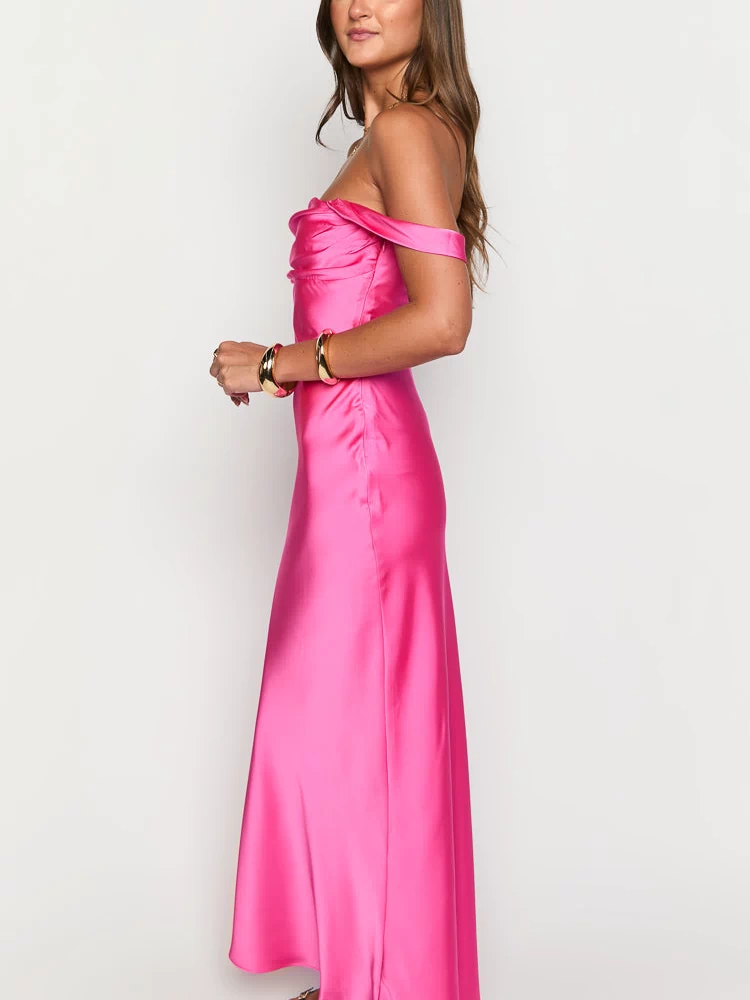 Side view of a hot pink satin off-shoulder formal dress with a draped neckline and flowing skirt