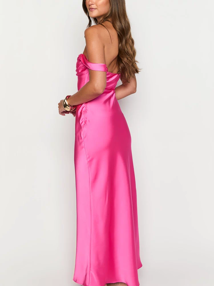 Side view of the hot pink satin off-shoulder formal dress with draped neckline and long flowing skirt