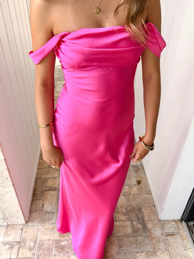 Full length hot pink off-shoulder formal dress with a draped neckline and a flowing maxi skirt