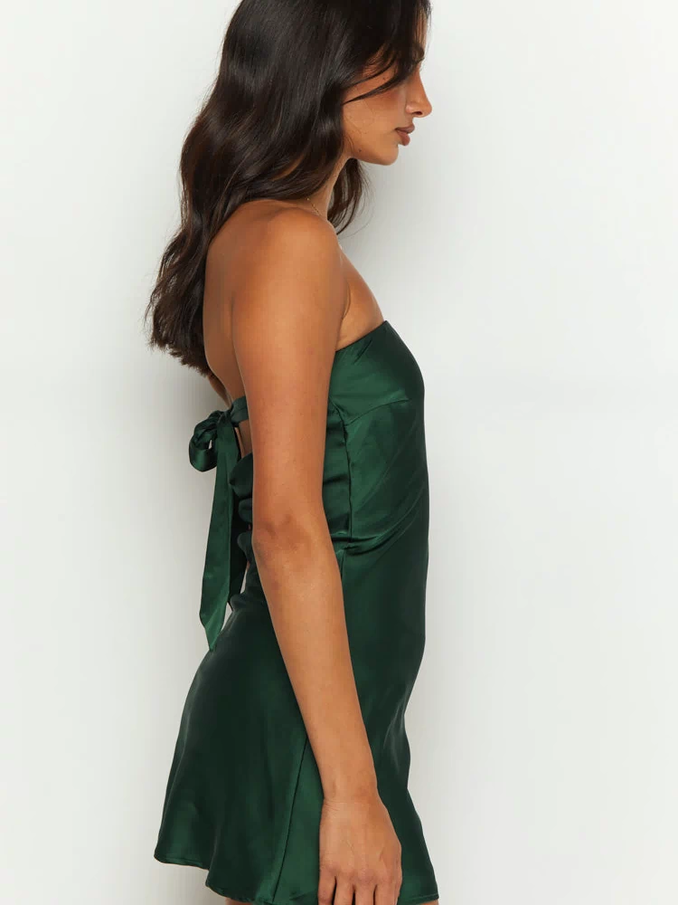 Side view of a forest green satin strapless mini dress with a tie-back detail