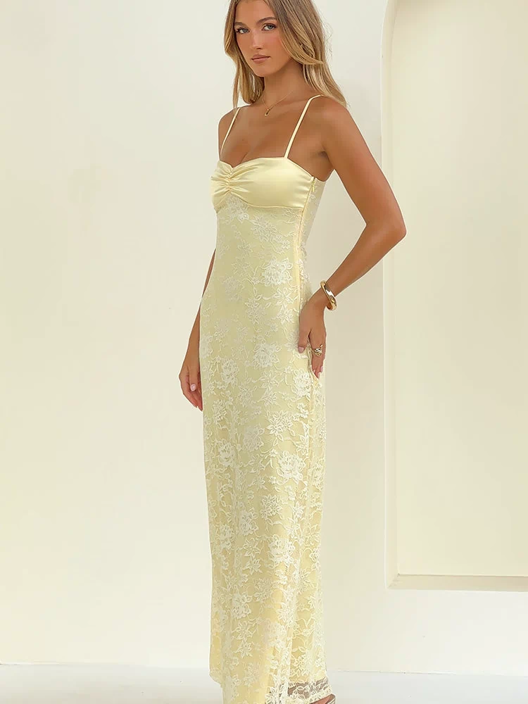 Side view of a yellow maxi dress featuring a ruched bust, thin spaghetti straps, and a floral lace overlay