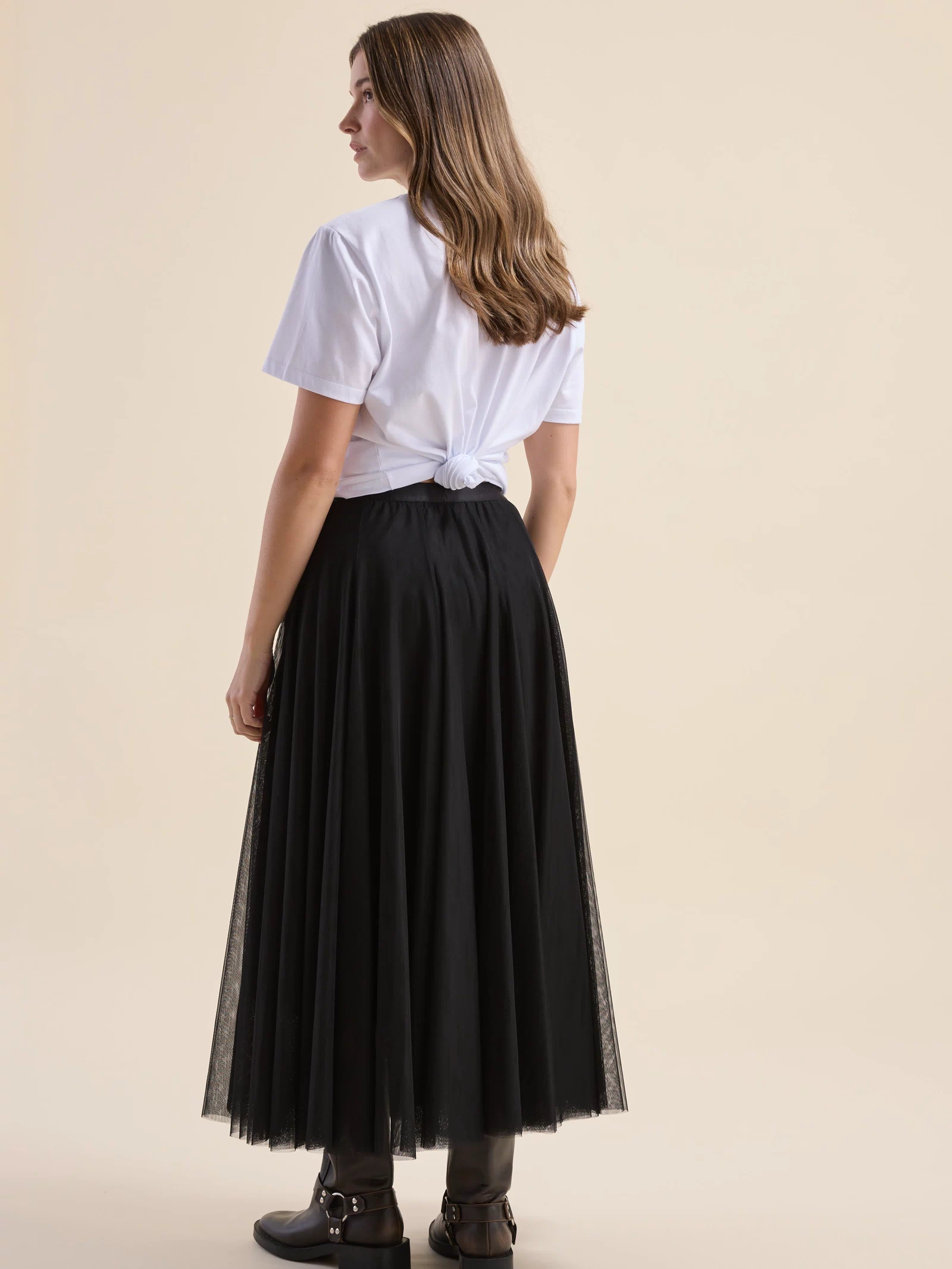 Woman in white tee and Max Emilie Tulle Skirt, back view, on a light background.
