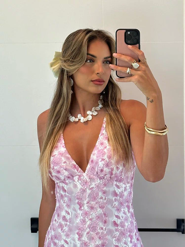 Side view of a pink lace maxi dress with a low scoop back and fitted bodycon silhouette