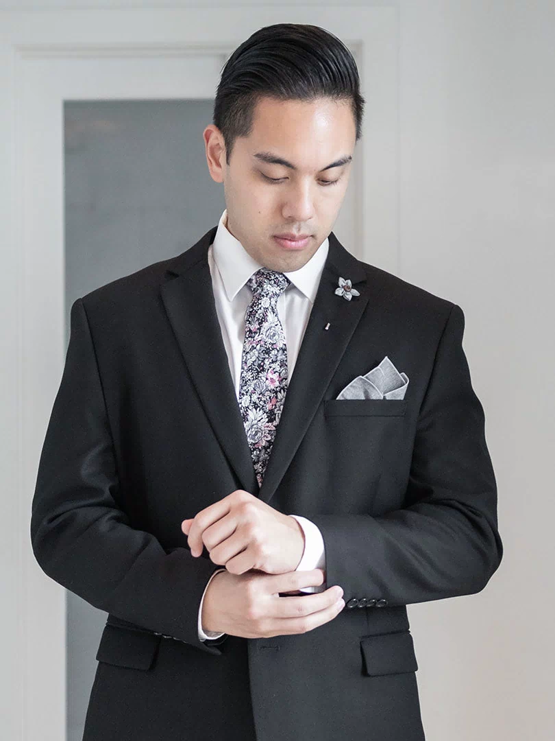 Floral Black cotton tie worn with a black suit jacket, a white shirt, a pocket square and a lapel pin
