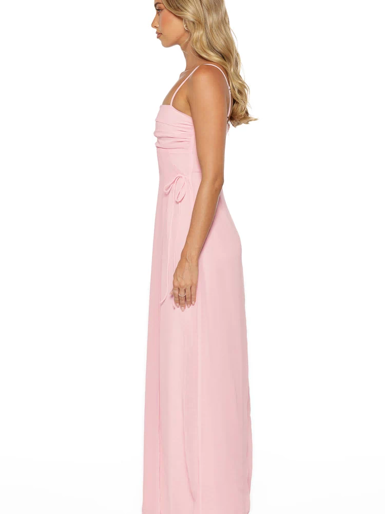 Side view of a pink maxi dress showing ruched bodice detail and side waist ties