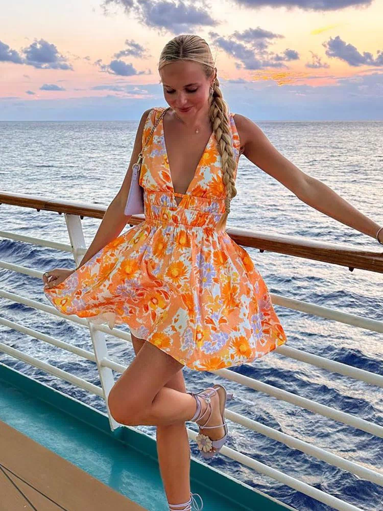 Orange floral mini dress with a deep V-neck, shirred waist, side cutouts, and a flowy skirt