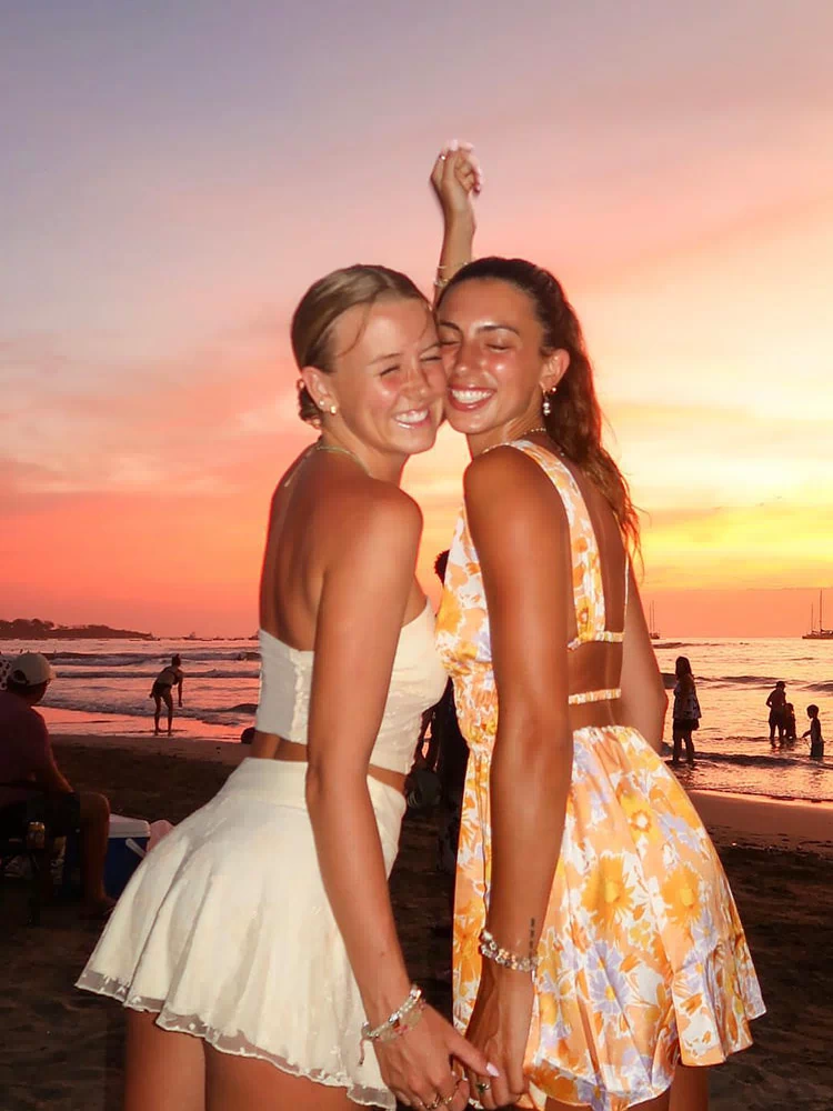 Rear view of an orange floral mini dress with a low open back and thin horizontal strap details