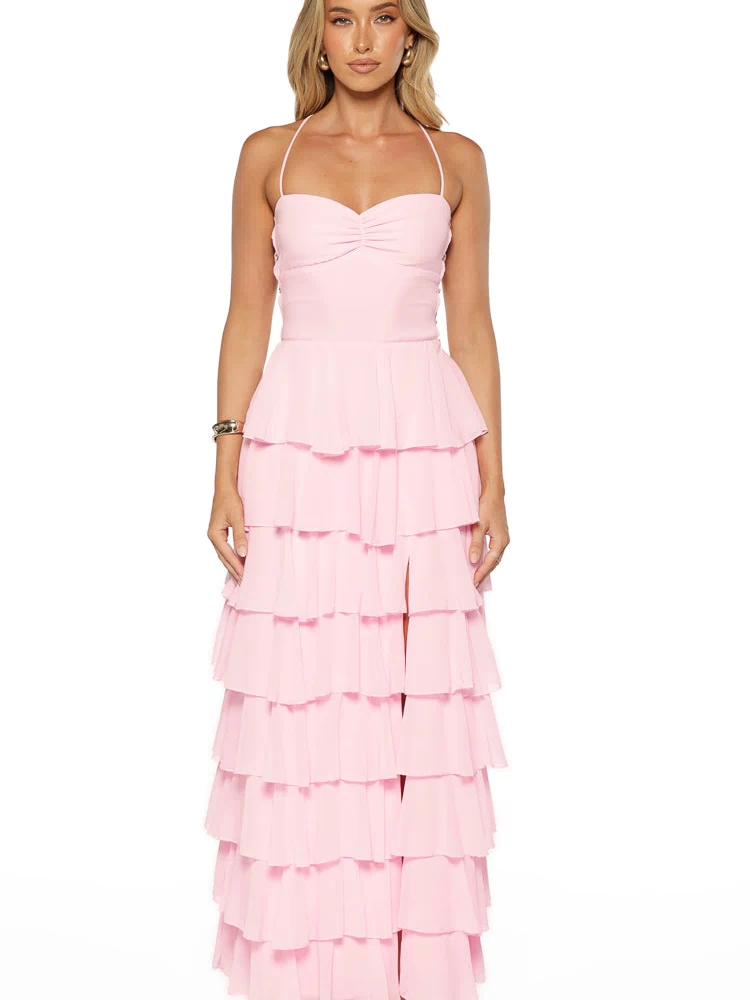 Pink maxi dress with a ruched sweetheart bust, delicate halter straps, and a tiered ruffle skirt with a high leg slit