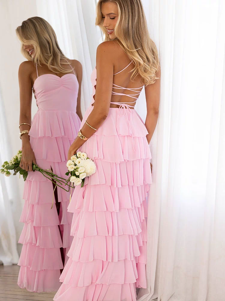 Back view of a pink maxi dress with a criss-cross lace-up back, side cutouts, and a full tiered ruffle skirt