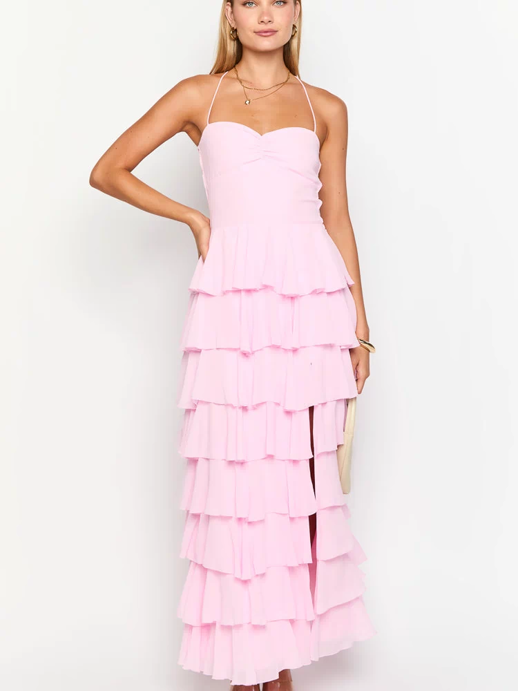 Full length front view of a pink tiered ruffle maxi dress with a ruched sweetheart halter neckline and side slit