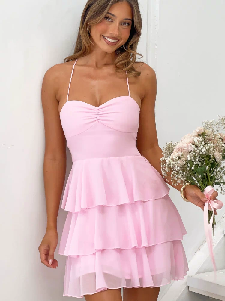 Pink mini dress with a ruched sweetheart neckline, thin spaghetti straps, and a tiered ruffle skirt