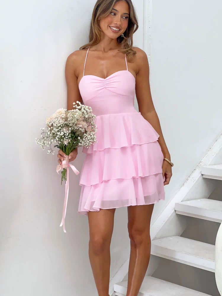 Front view of a pink mini dress with a ruched sweetheart neckline and three tiers of ruffles