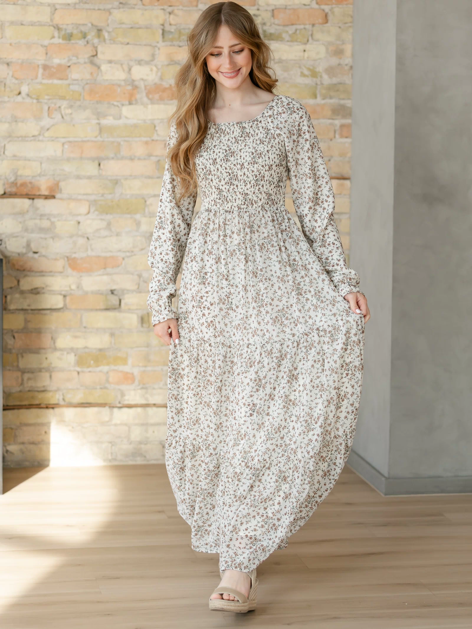 Gia ivory floral maxi dress with smocked bodice, long sleeves, and tiered skirt.