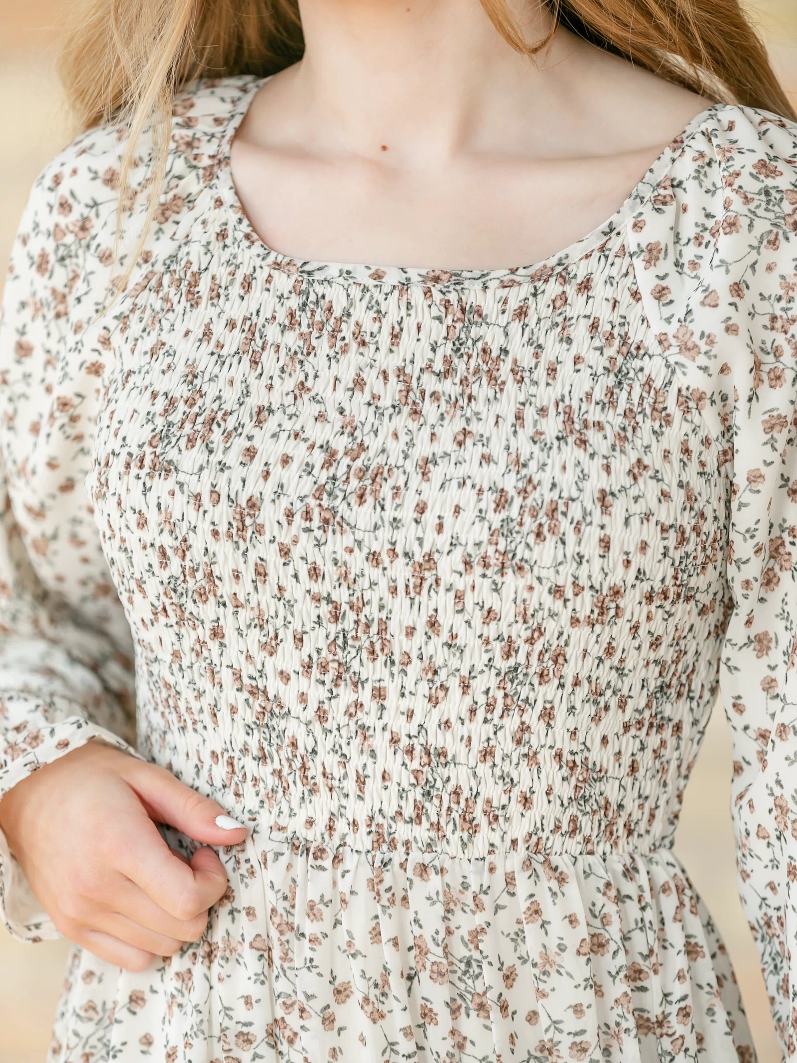 Close-up for the smocked bodice of a floral dress.