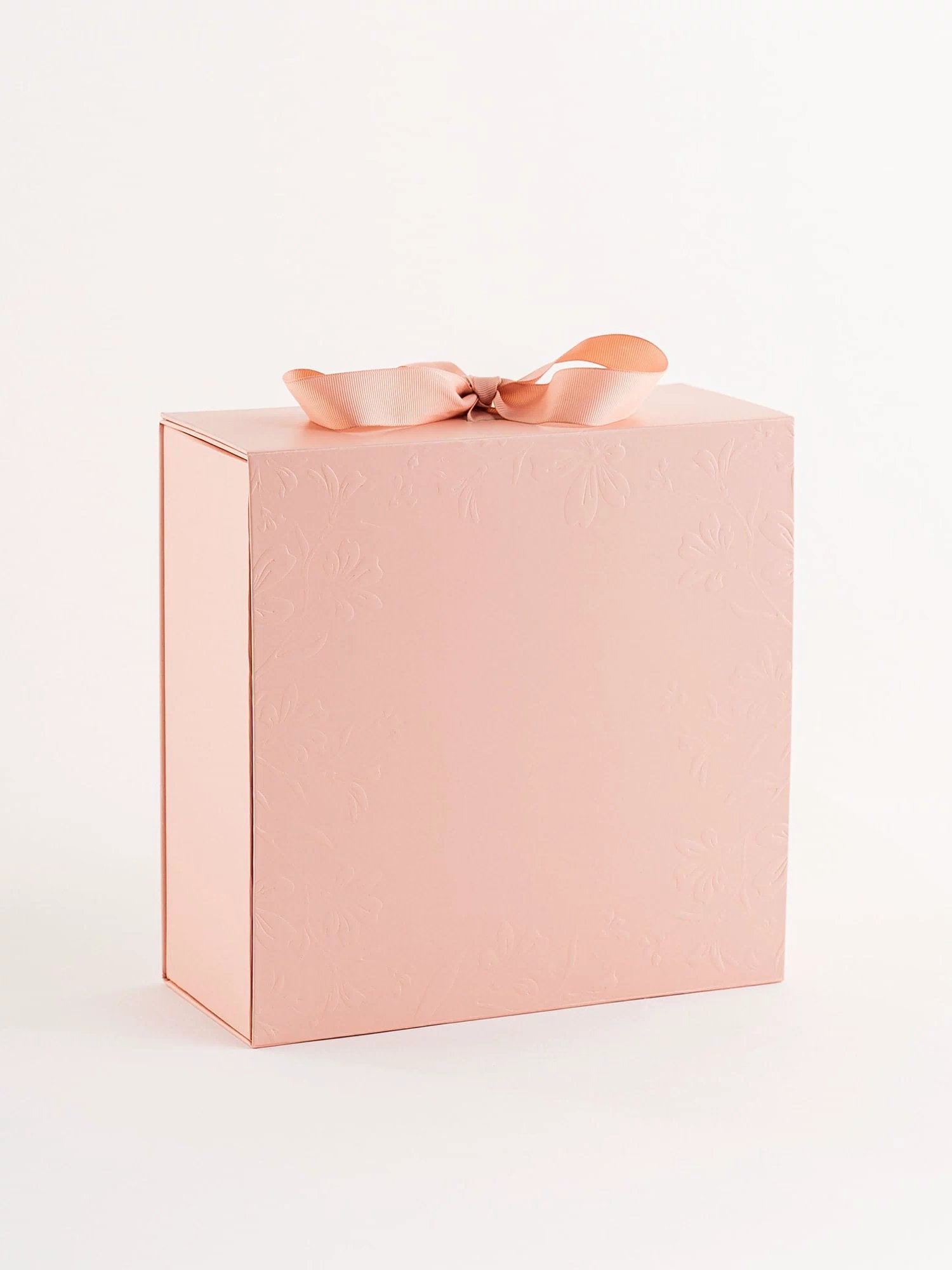 Pink gift box with a ribbon on a light gray background