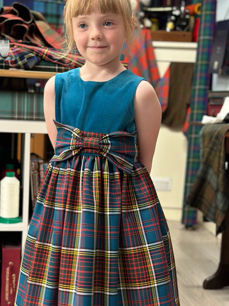 Close-up of the Girls Tartan and Velvet Dress details, featuring a matching tartan scrunchie and optional underskirt.