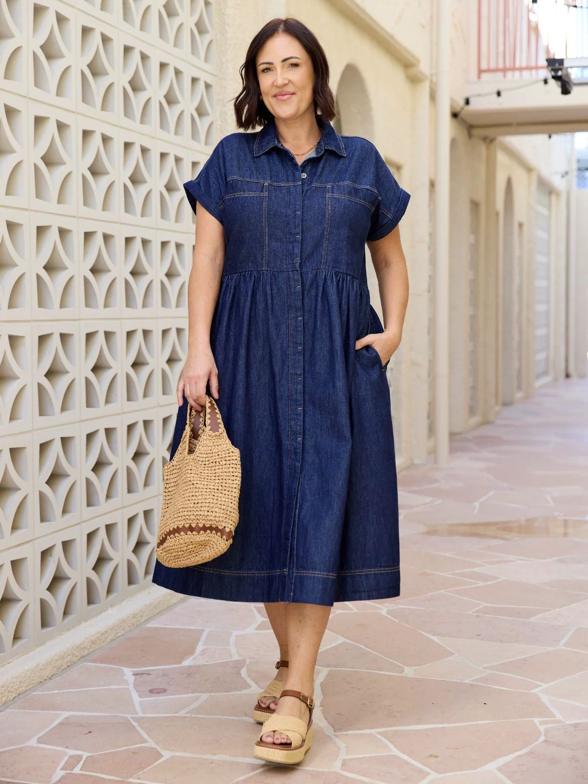 Harper petite denim dress in indigo on a petite model, button‑down collar, short sleeves, midi length ending above the ankle.