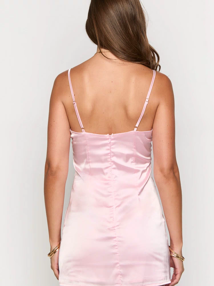Rear view of a light pink satin mini dress with adjustable spaghetti straps and a visible back zipper