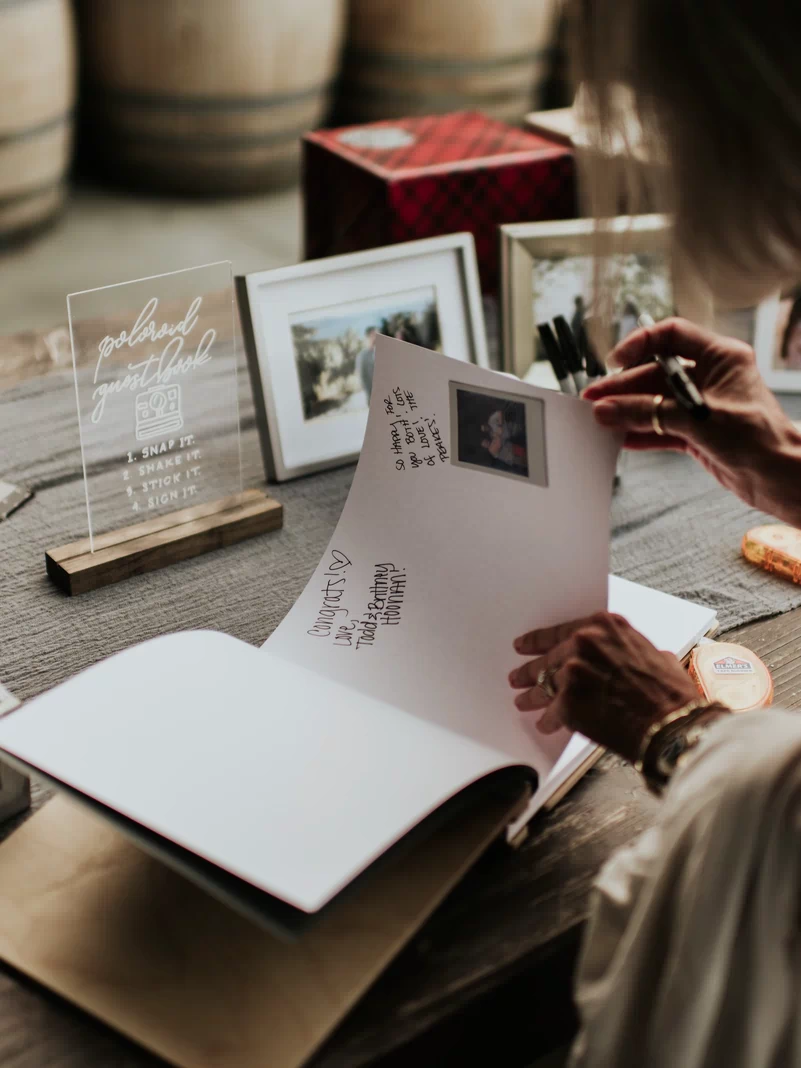 a woman sitting at a table holding a piece of paper