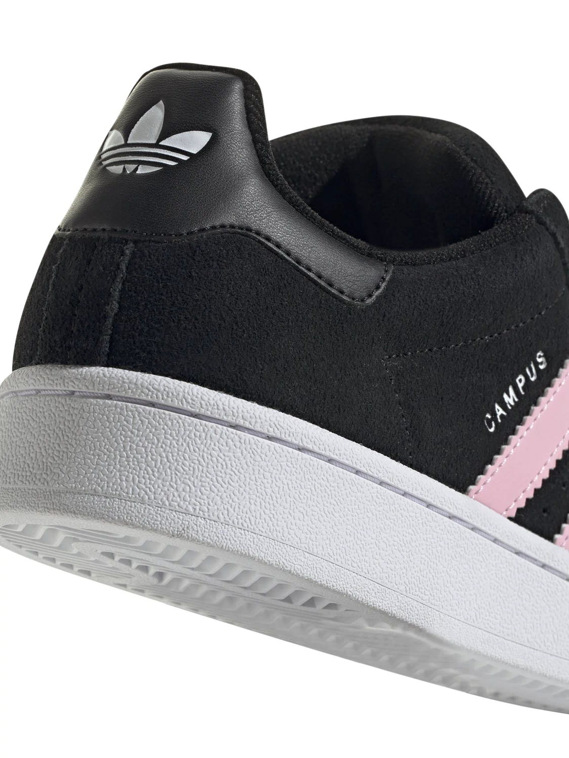 Side view of black suede sneakers with pink stripe accent, white midsole and collar.