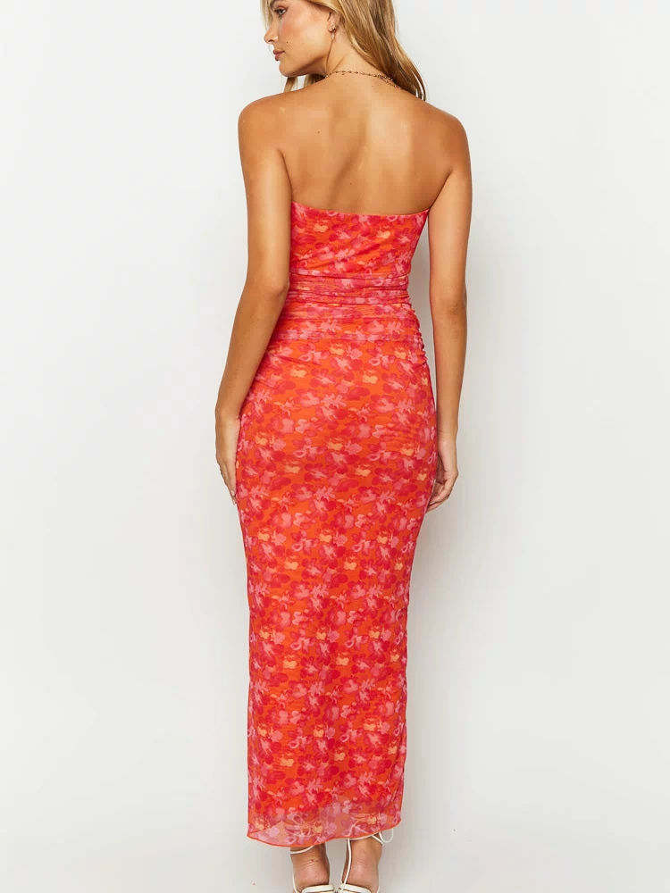 Rear view of an orange floral print strapless bodycon maxi dress with ruched waist detail