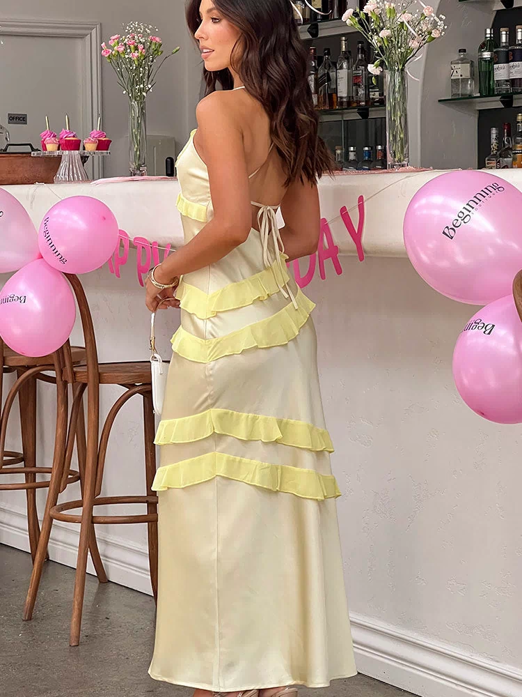 Rear view of a yellow satin maxi dress with criss-cross tie-up back and tiered ruffles