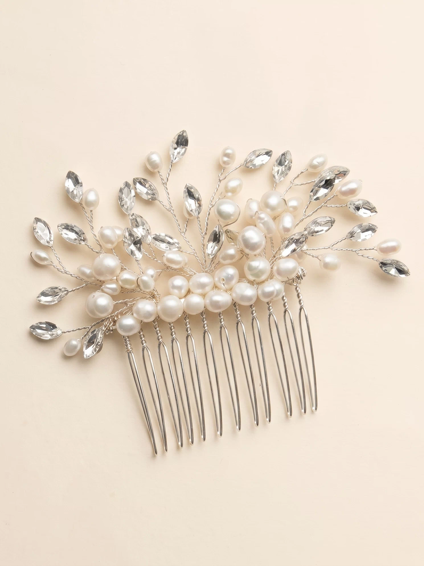 A decorative hair accessory with a comb and a floral design made of pearls and crystals.
