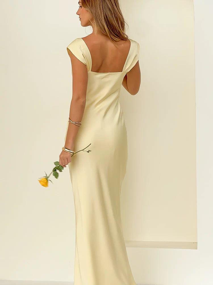 Rear view of a yellow satin maxi dress with a square back neckline and short cap sleeves