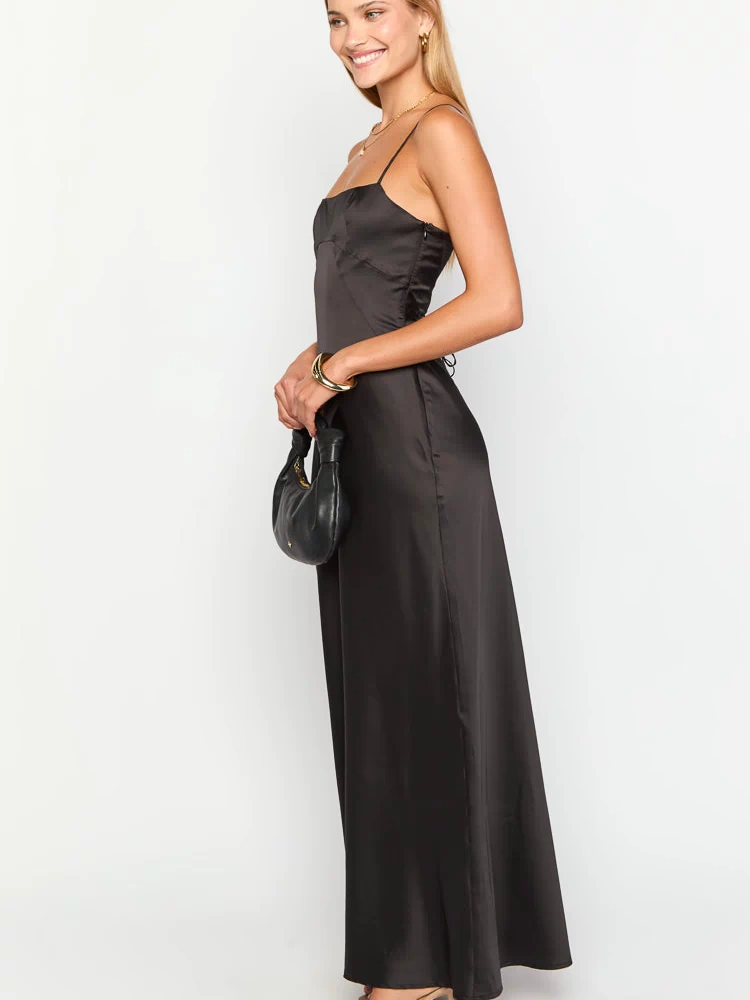Side view of a black satin maxi dress with a square neckline, thin spaghetti straps, and side lacing detail on the bodice