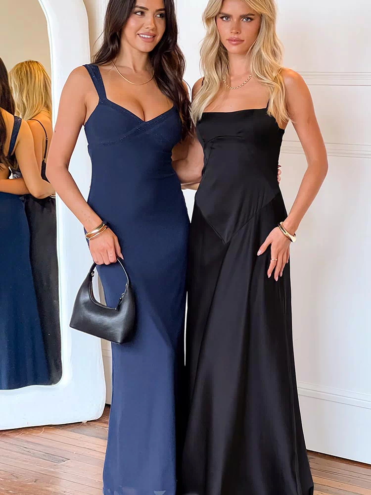 Black maxi dress with a square neckline, thin spaghetti straps, and a flowing skirt with subtle paneling