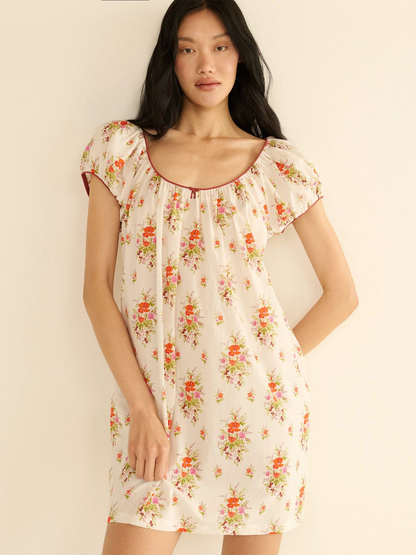 Woman wearing a floral dress against a plain background