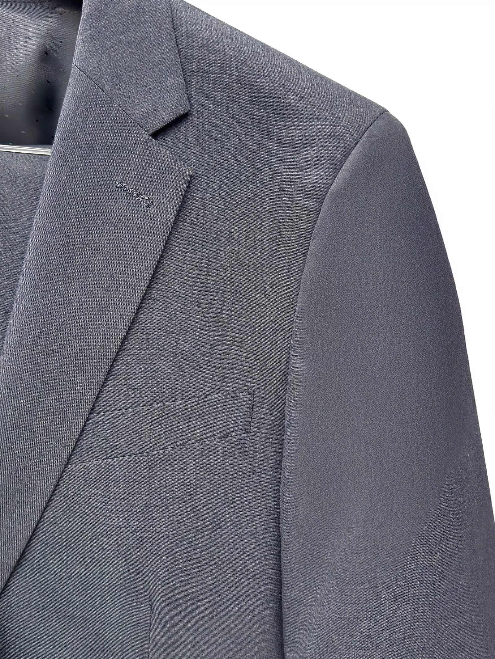 Close-up of the Mens Charcoal Suit by Karako Men on a hanger, showcasing the lapel, chest pocket, and shoulder details.