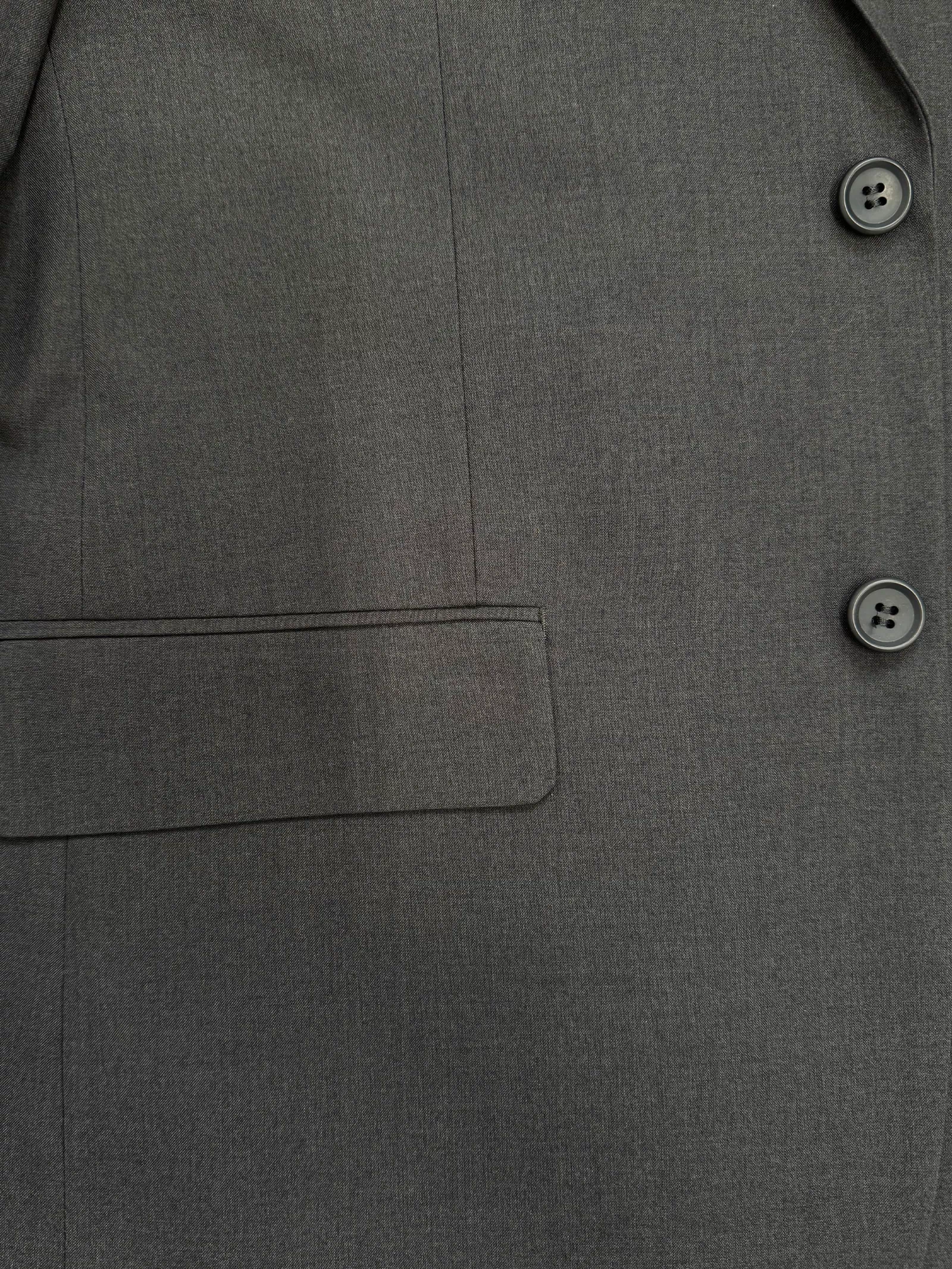 Close-up of the Karako Men Mens Charcoal Suit jacket, featuring two buttons, a seam, and a flap pocket.