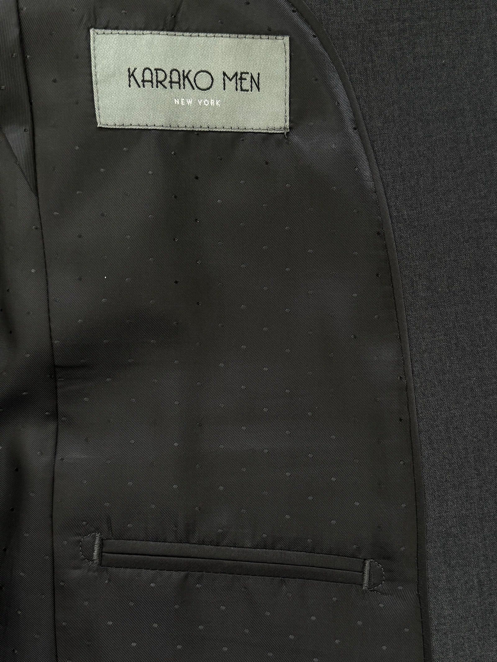 Close-up of the inside lining of a Mens Charcoal Suit by Karako Men, showing a label with the brand name above an interior pocket.
