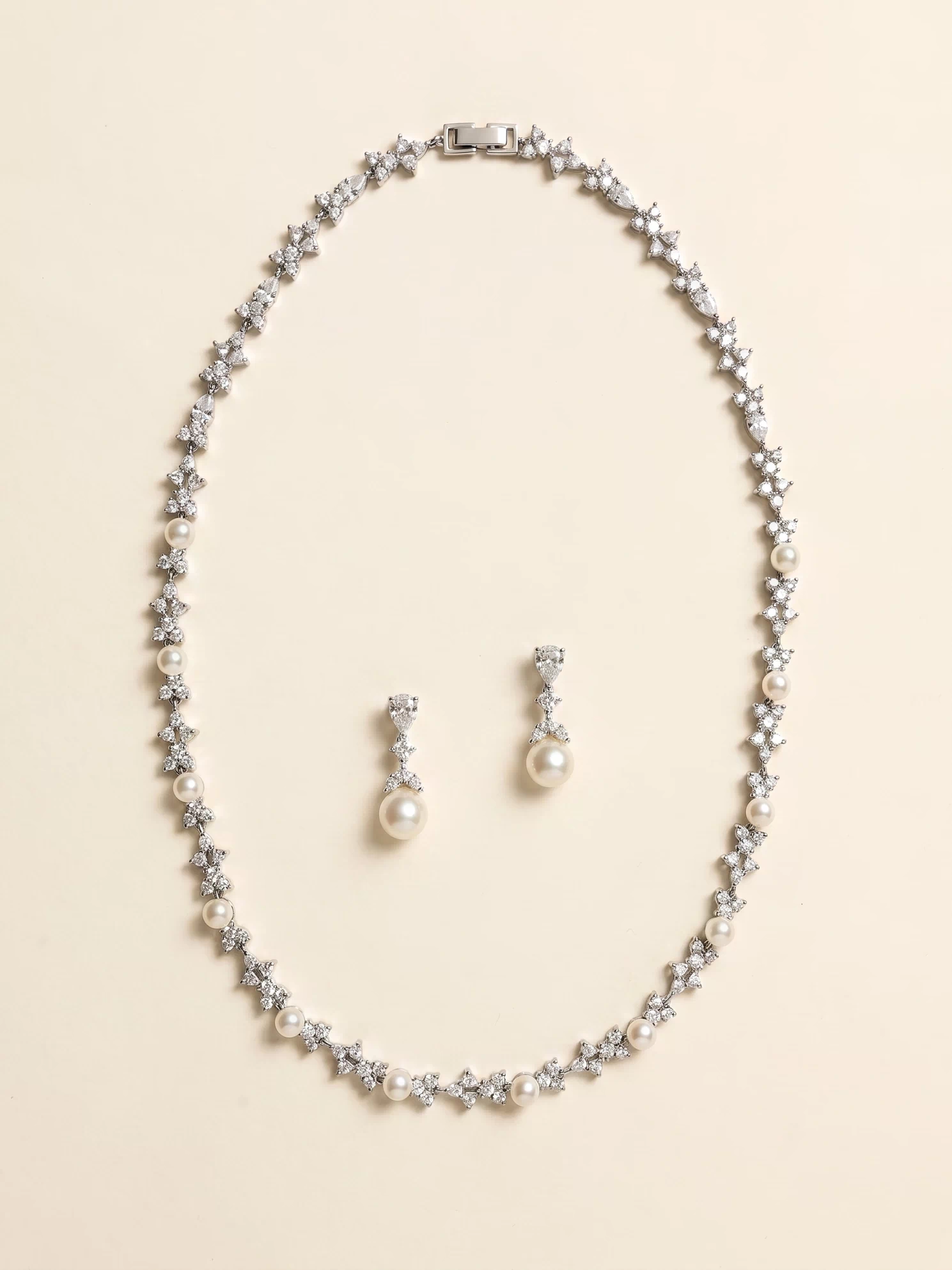 A necklace and earrings set made of silver and white pearls and diamonds.