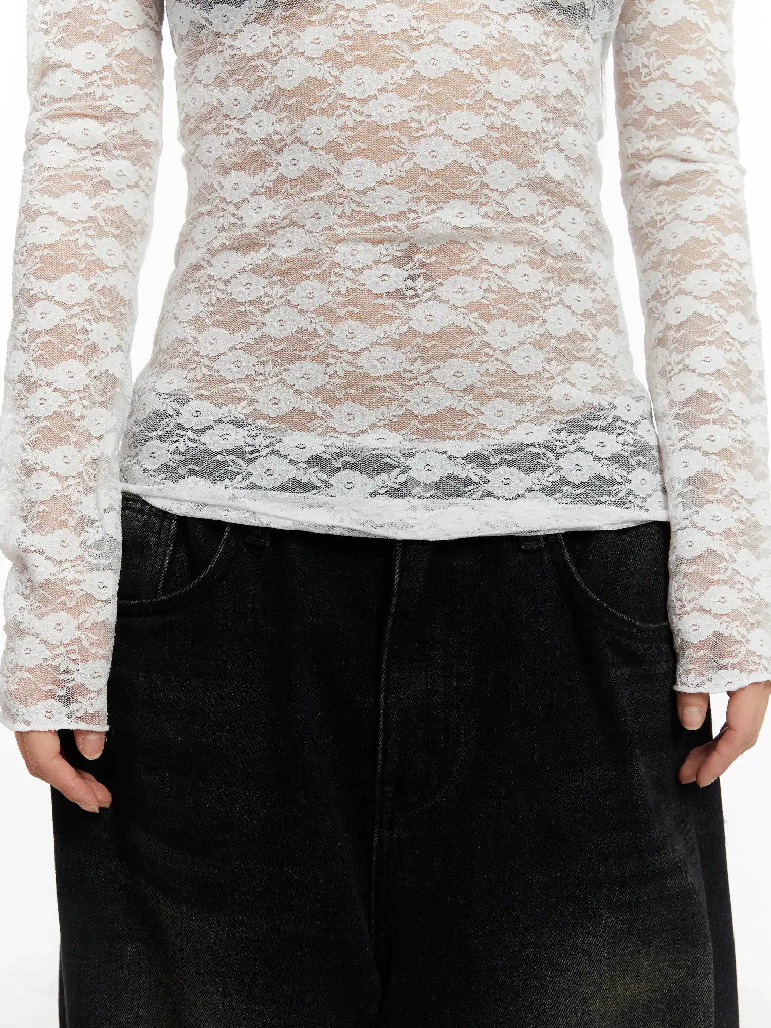 Lace Sheer Long Sleeve Top CD512 in white, torso close-up showing lace hem trim detail and floral pattern, sheer slim fit, worn over bra with black wide-leg jeans.