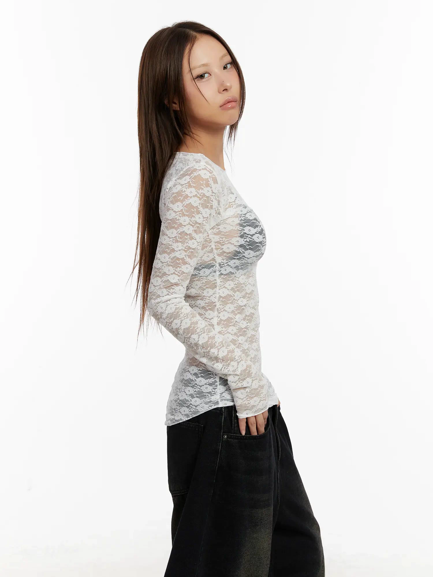 Lace Sheer Long Sleeve Top CD512 in white, side view on model, slim-fit sheer floral lace long sleeve highlighting body-skimming silhouette, paired with black jeans.
