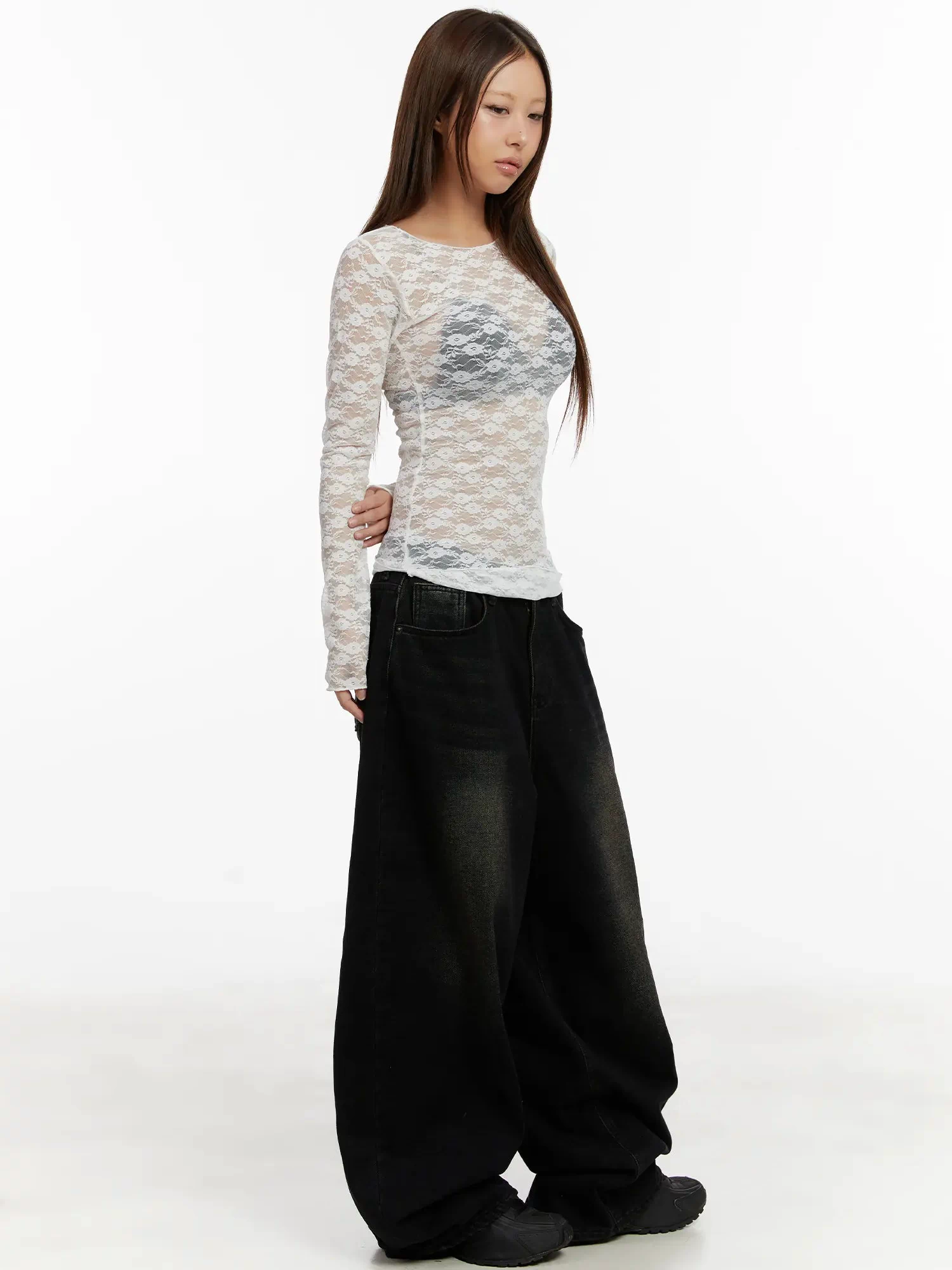 Lace Sheer Long Sleeve Top CD512 in white, three-quarter side view full-length on model, sheer floral lace slim fit, styled with oversized black wide-leg jeans and chunky shoes.