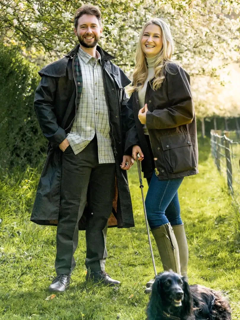Couple in a traditional wax jacket with their dog enjoying the outdoors together