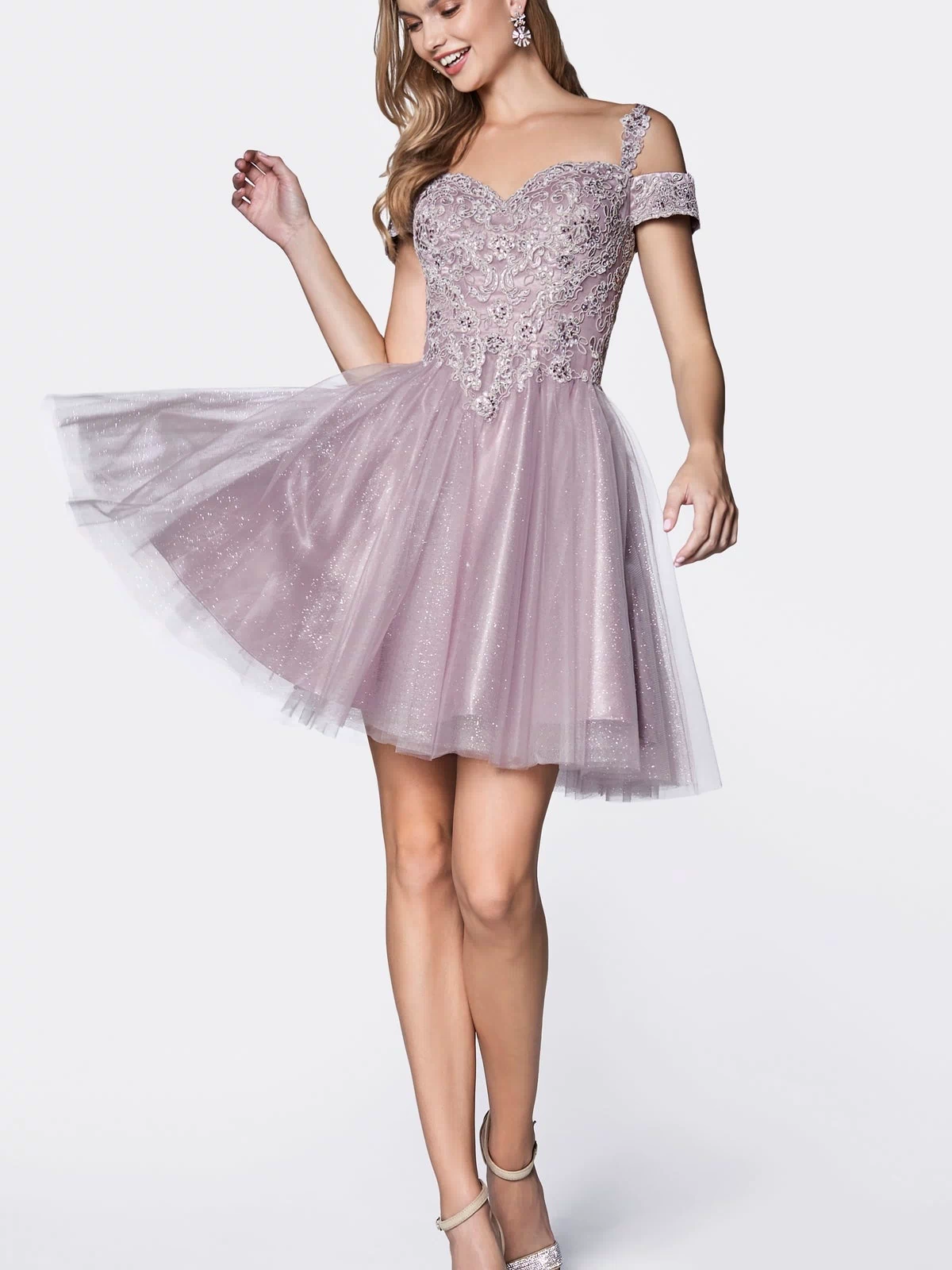 A woman poses elegantly in the Cold-Shoulder Short Glitter Homecoming Dress CD0132, featuring light purple fabric, floral embellishments, a tulle skirt, and cold-shoulder style against a plain white background.
