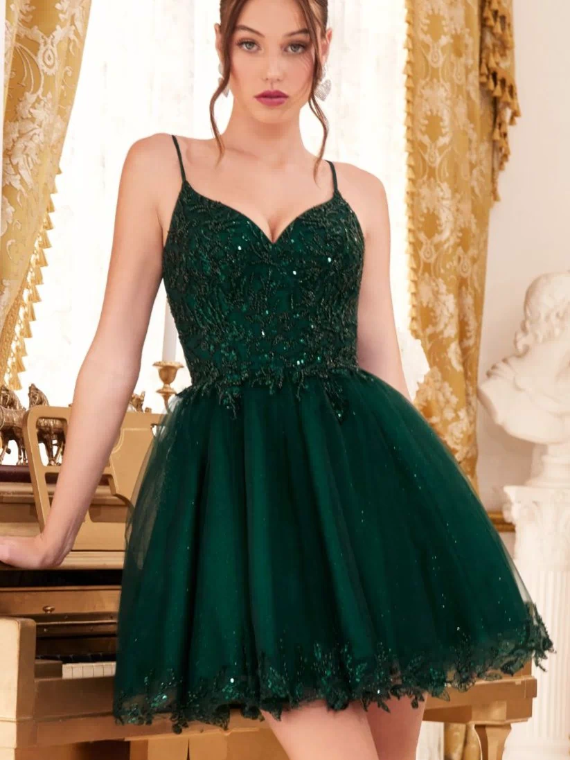 A woman wears the Short Homecoming Dress CD0213 with embroidery, featuring dark green sequins and a sleeveless design, as she stands in front of a gold piano with ornate gold curtains in the background.