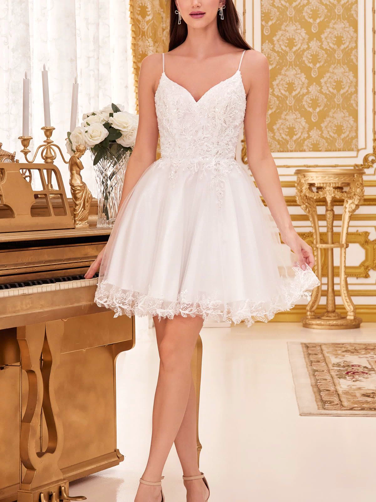 A woman in the Short Homecoming Dress CD0213 with embroidery and nude heels stands beside a gold piano in an ornate, gold-accented room.