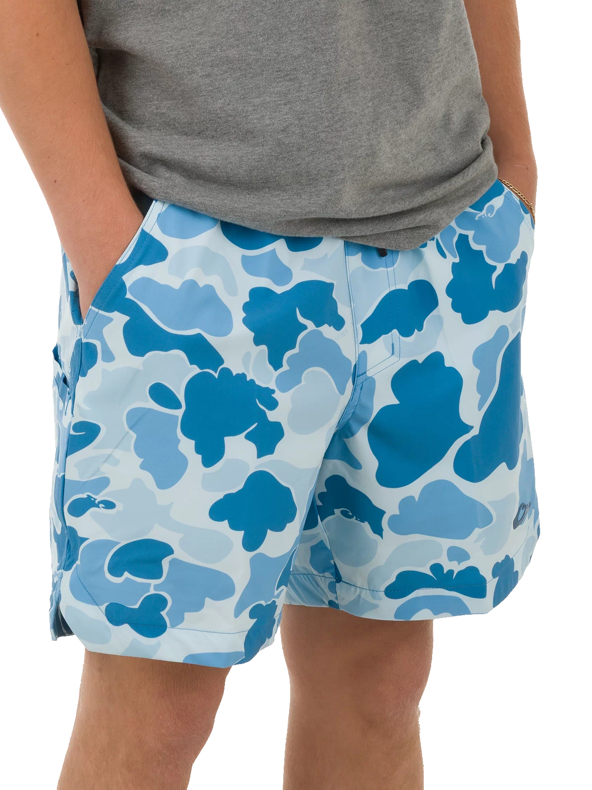 Person wearing Lake Shore Dock Short with floral camo pattern, plain grey T-shirt, and gold chain bracelet. Shorts feature elastic waistband and mesh-lined pockets.