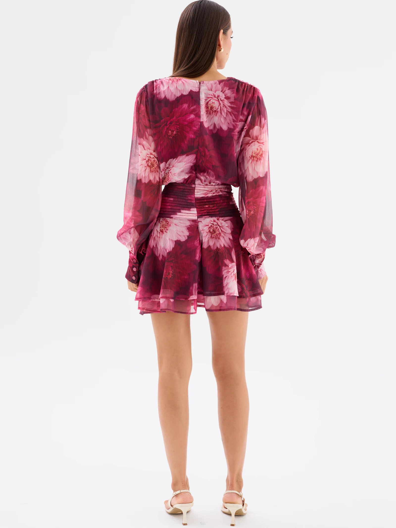 Full back view: Lanarah Mini Dress in Ruby Dahlia with a plunging V-neckline, draped bodice, long sheer blouson sleeves, fitted pleated waistband and flowing mini-length silhouette.