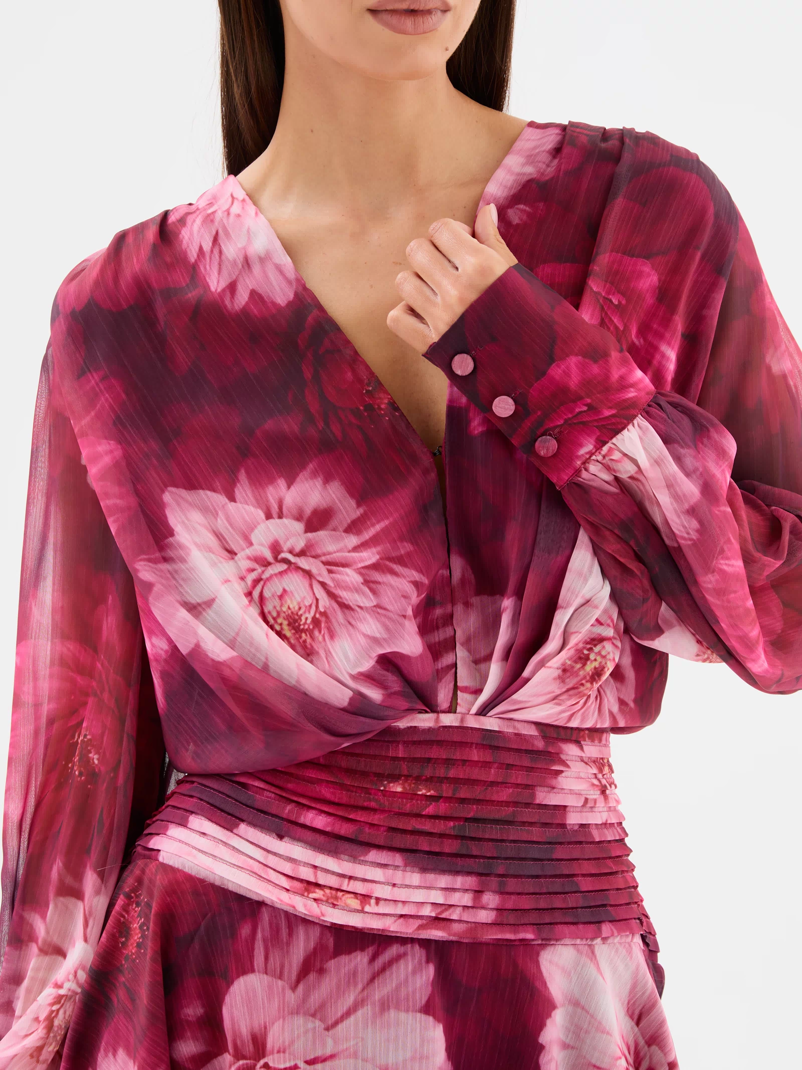 Detail close up view: Lanarah Mini Dress in Ruby Dahlia with a plunging V-neckline, draped bodice, long sheer blouson sleeves, fitted pleated waistband and flowing mini-length silhouette.