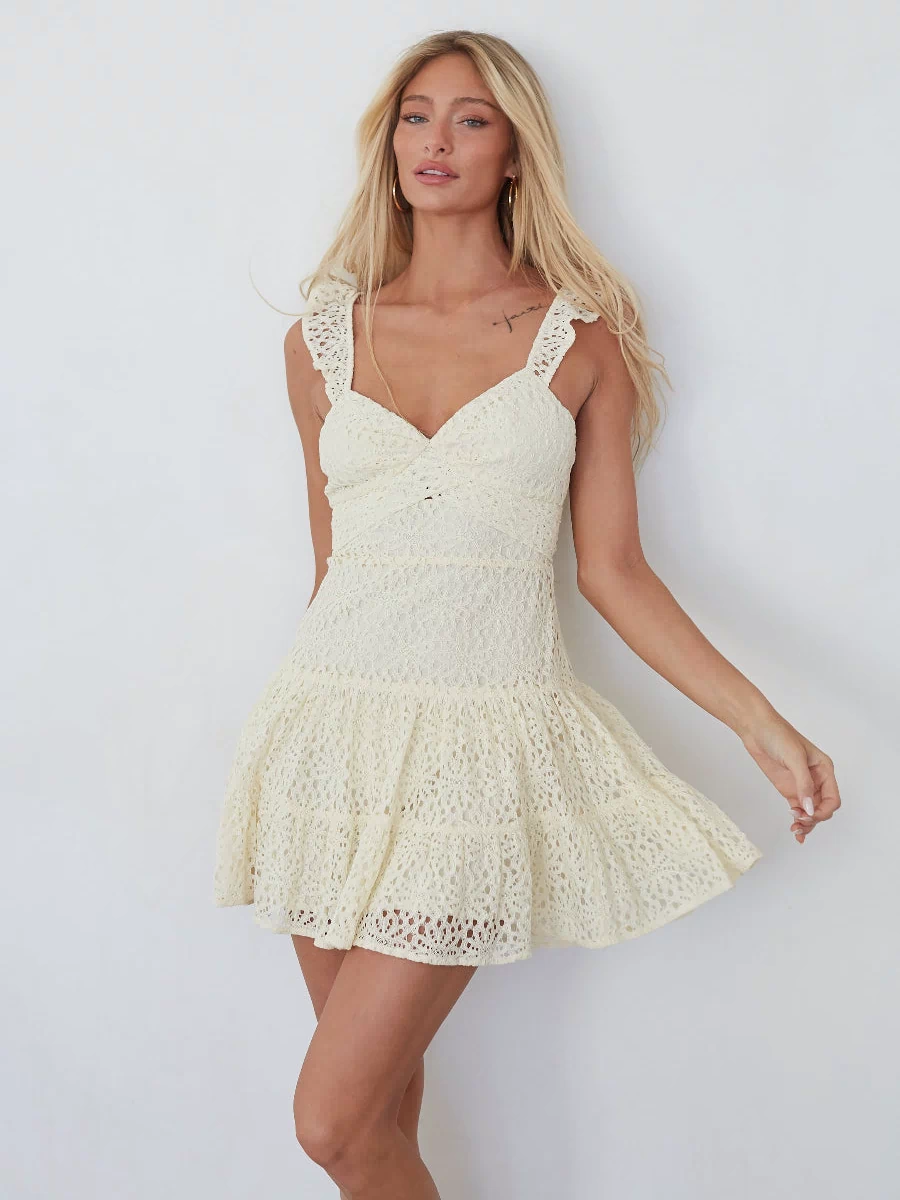 yellow-image | Woman wearing a white lace dress against a plain background