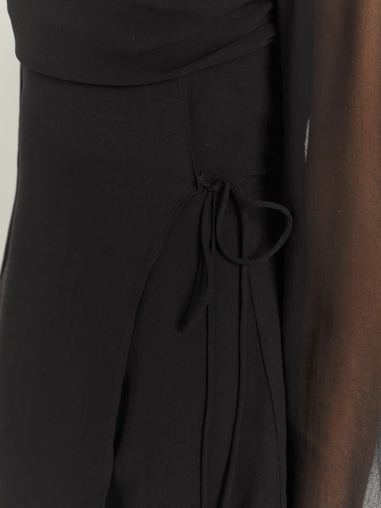 Close-up of the black mini dress side tie detail creating an adjustable slit and subtle ruching