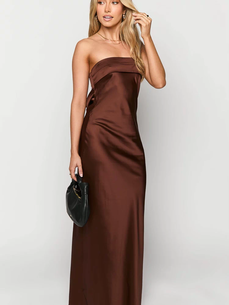 Front view of a brown satin strapless maxi dress with a folded bust detail and side tie
