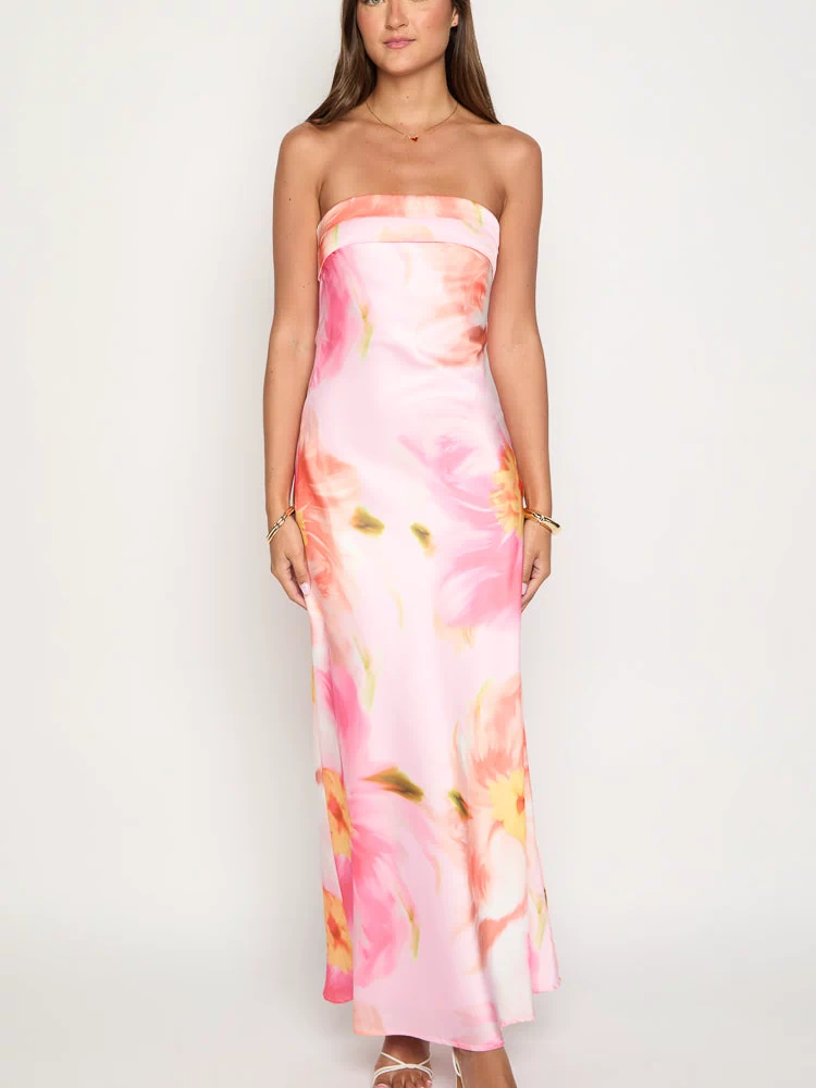 Front view of a pink strapless maxi dress with a straight neckline and a vibrant abstract floral print in orange, yellow, and green